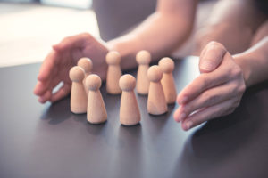 Woman's hands protecting eight ornamental figures arranged in a circle